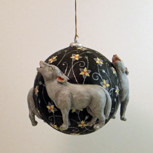 Pappmacheekugel mit drei heulenden Wölfen, einer frontal , einer taucht auf, einer geht und man sieht nur noch den Schwanz und ein Bein